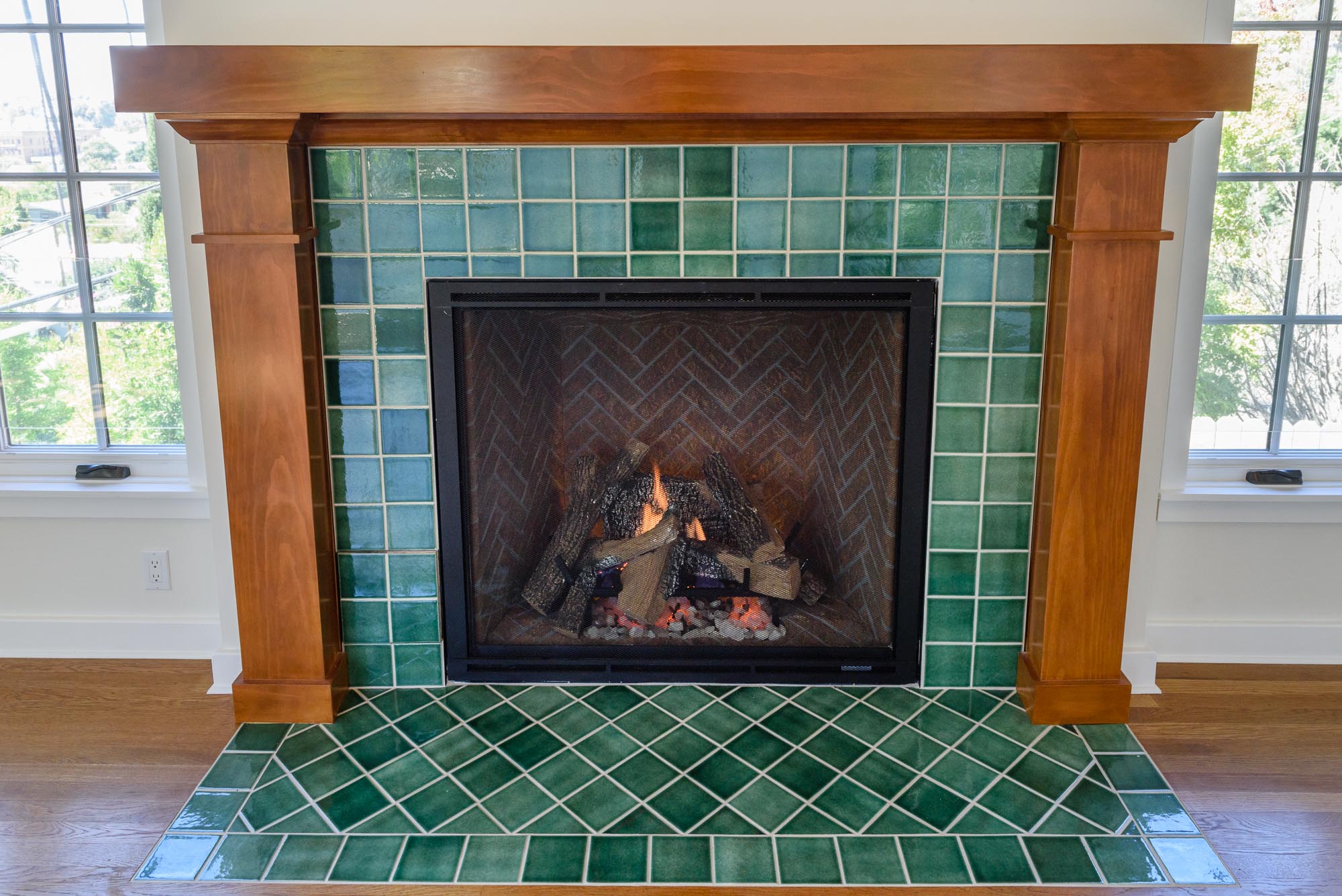  Easy to use remote control gas log fire framed with beautiful hand-made tile surround and wood mantel. 